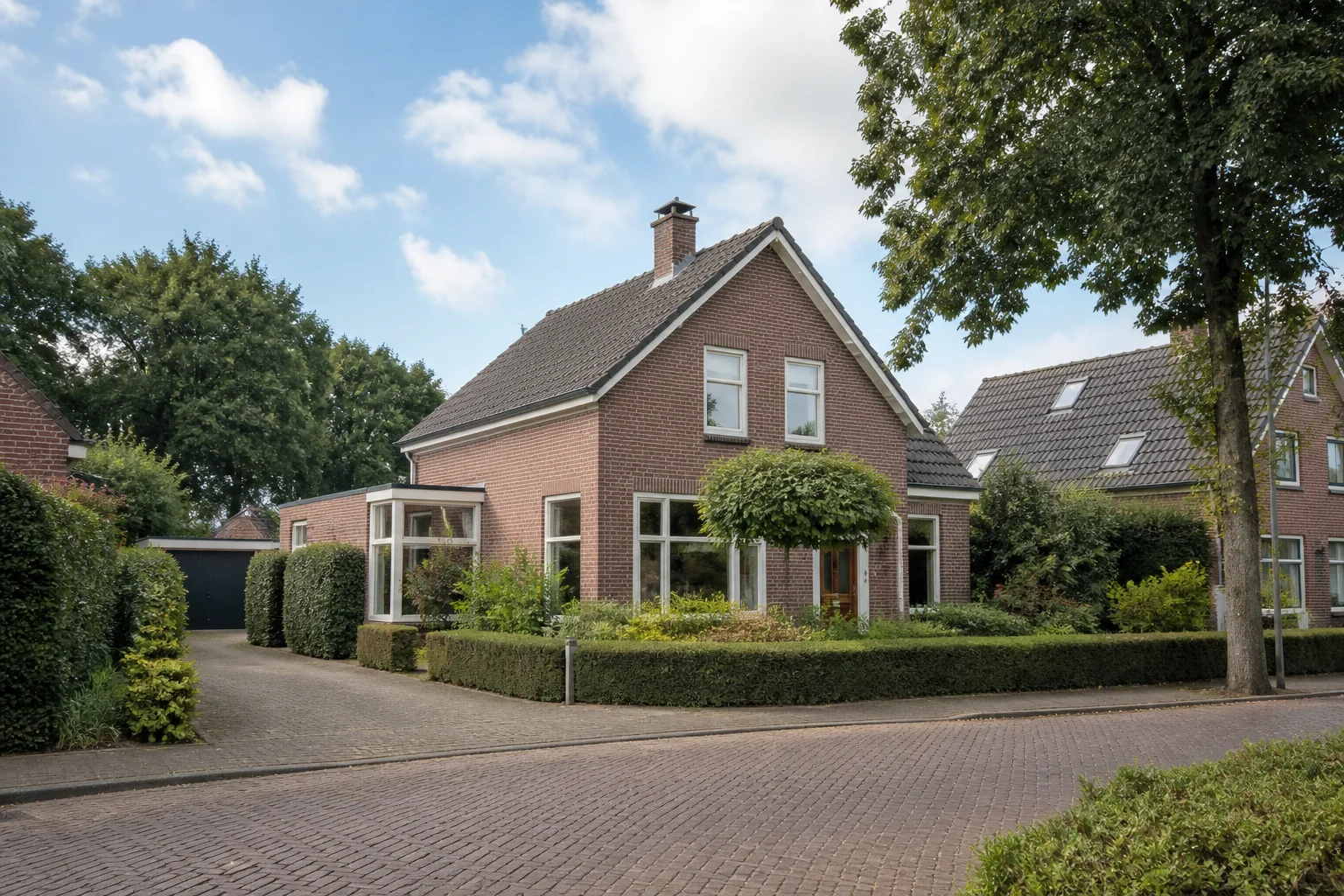Representative brick family home with garden and driveway in Knegsel