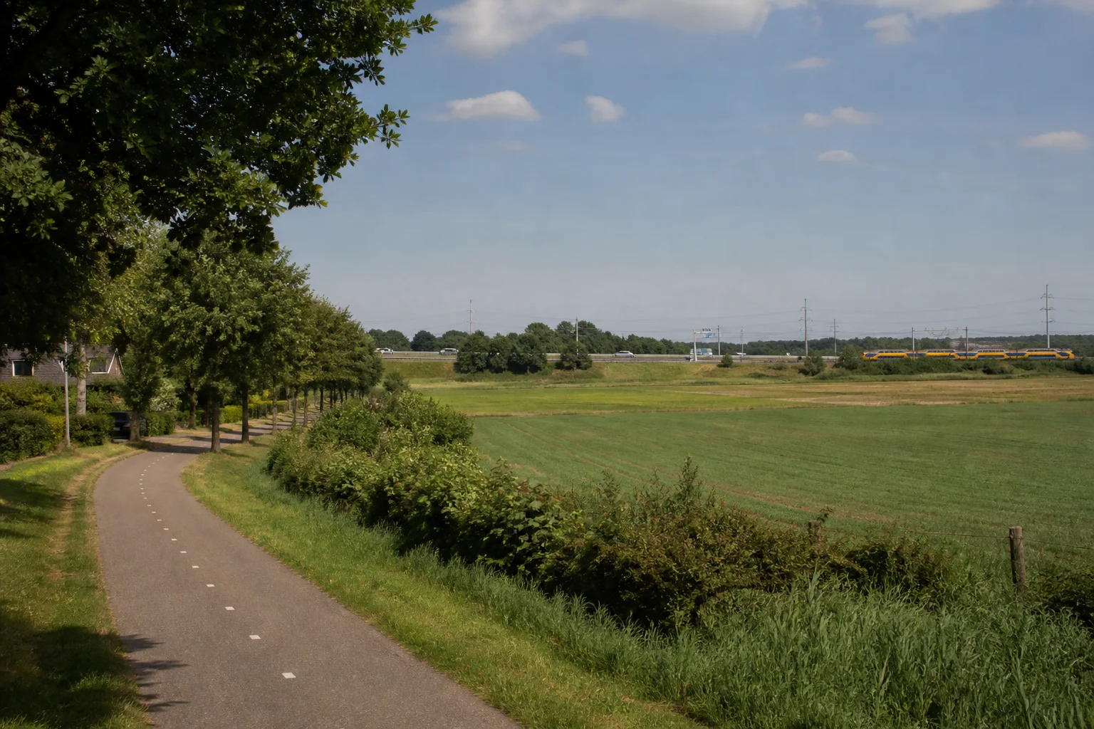 Maarheeze village edge with a cycling connection, open Brabant fields, railway and green landscape